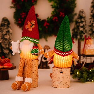 Close-up of glowing Christmas gnome with LED lights and gingerbread man knit hat