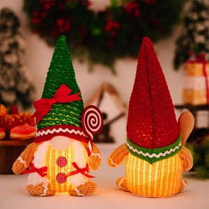 Detail of two light-up Christmas gnomes with warm LED glow and knit gingerbread patterns