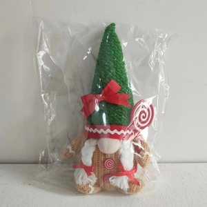 Detail of Christmas gingerbread gnome featuring a green knit hat and white braids