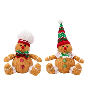 Sitting gingerbread plush dolls with Christmas hats and decorative scarves on white background