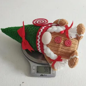 Close-up of a gingerbread gnome plush showing the 96.1g weight on a kitchen scale