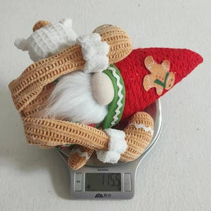 Detailed view of 115.5g Christmas gnome plush with gingerbread motif on kitchen scale