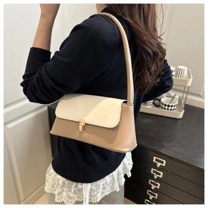Detail of minimalist two-tone underarm bag with elegant gold square metal clasp and leather strap