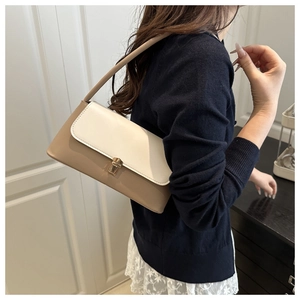 Détail du sac à bandoulière crème et kaki avec boucle carrée dorée et fine bandoulière