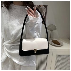 Detail of minimalist black and white leather handbag with golden buckle and sleek handle
