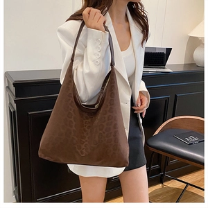 Detailed view of brown leopard print tote bag featuring matte texture and leather handle