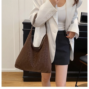Fashionable brown leopard print tote bag styled as a large shoulder hobo bag on a model
