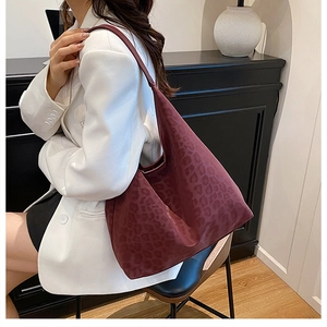 Deep burgundy leopard print canvas tote bag shown as a spacious underarm hobo style shoulder bag