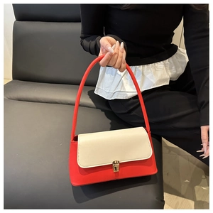 Détail du sac bandoulière rouge et beige avec boucle métallique dorée rectangulaire