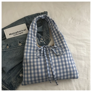 Detail of blue and white checkered fabric tote bag with elegant bow tie closure