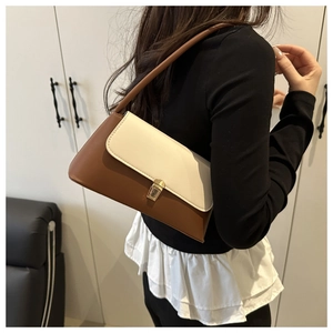Close-up of contrast color shoulder bag with beige flap and gold metal buckle