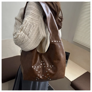 Detail view of brown faux leather hobo bag with vintage metal rivet star pattern