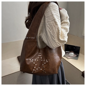 Close-up of vintage brown tote bag with star-shaped silver rivet studs decoration