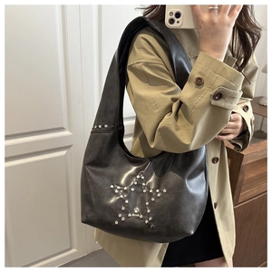 Detail of black faux leather tote featuring a silver metallic star rivet pattern