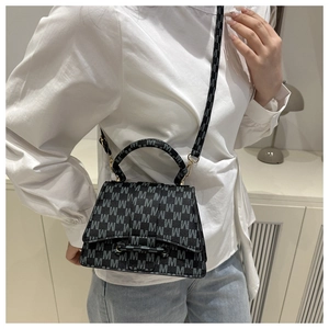 Lifestyle foto van een vrouw met een zwarte bedrukte crossbody tas met riem