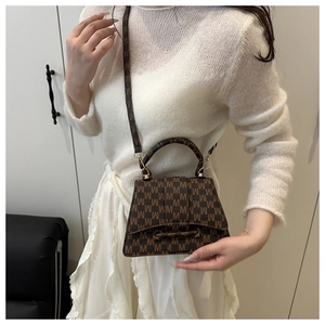Brown jacquard square bag with M-pattern and gold hardware shown on a model