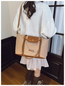 Rear view of a large two-tone tote bag worn by a model for a stylish casual daily look