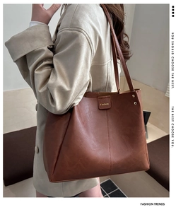 Detailed close-up of brown faux leather tote bag with fine texture and vintage rivet accents