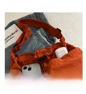 Details einer leuchtend orangefarbenen Nylon-Tasche mit Fokus auf das große Innenvolumen
