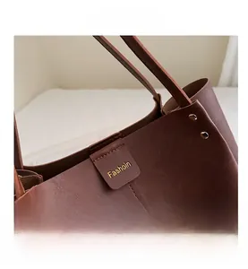 Detail of vintage brown tote bag showing magnetic buckle closure and leather texture