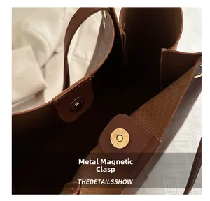 Detail view of the secure magnetic closure on a brown vintage faux leather tote bag