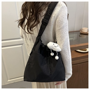 Detail of black drawstring bucket bag with a cute white cloud plush pendant accessory