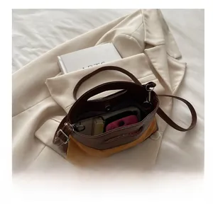 Top-down view showing interior capacity and mixed leather texture of the handbag