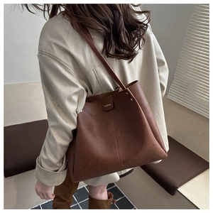 Close-up of vintage brown tote bag with fashion gold logo and smooth matte leather texture