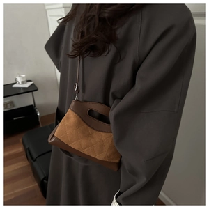 Detail of vintage quilted crossbody bag with brown leather trim and slim shoulder strap