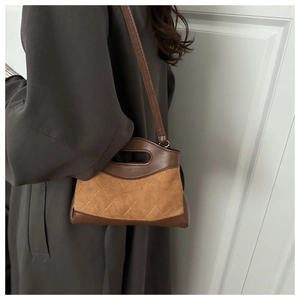 Close-up of quilted leather stitching and premium contrast textures on a dark brown handbag