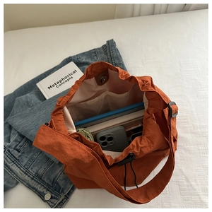 Top view of orange nylon bucket bag with large capacity and multi-compartment storage