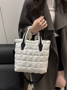 White quilted puffer tote bag with black handles and shoulder strap for women
