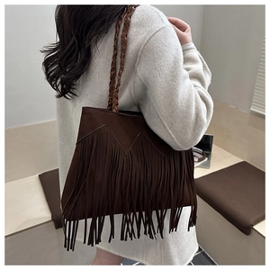 Detail of dark brown suede bucket bag with long tassels and woven shoulder strap