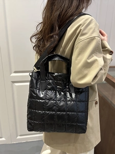 Quilted black nylon bucket bag with puff texture and adjustable strap for women