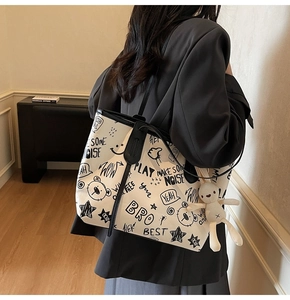 Close-up of graffiti tote bag with bear prints and a white rabbit plush pendant