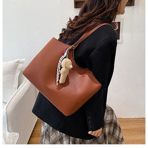 Brown large capacity tote bag with plaid scarf and plush bear charm on model
