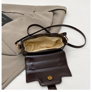 Vue détaillée du sac bandoulière en cuir marron foncé avec rabat et doublure beige