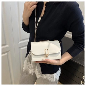 Nahaufnahme der weißen Leder-Umhängetasche mit goldener Schnalle und eleganter Kette