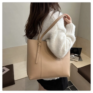 Minimalist beige leather tote bag styled with a white knit sweater for a daily commute look