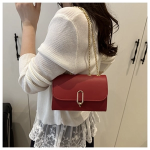 Close-up of red PU leather flap bag featuring golden U-shaped buckle and chain strap