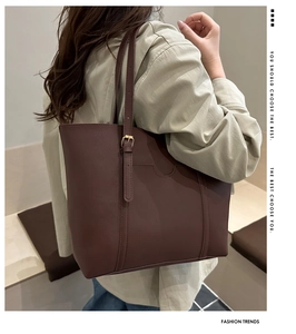 Detail of dark brown PU leather tote bag showing adjustable gold buckle and fine stitching