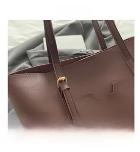 Détail du sac cabas en cuir marron avec boucle dorée et coutures de haute précision