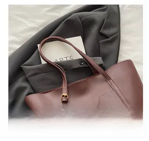 Vue macro du cabas en cuir marron rouge foncé avec boucle en métal dorée ajustable