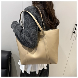 Grand sac cabas en cuir kaki porté à l'épaule, idéal pour les tenues décontractées ou de bureau
