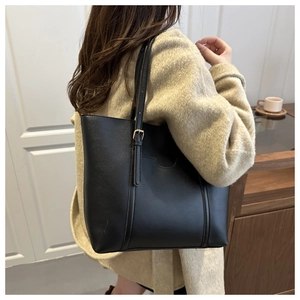 Détail du grand sac cabas noir mat avec boucles dorées et bandoulière réglable