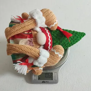 Close-up of a lit gingerbread plush doll being weighed on a scale at 106.8 grams