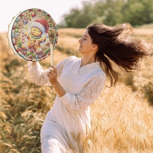 Outdoor close-up of a Christmas gingerbread man tambourine with a soft pompom drumstick