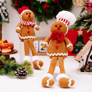 Detail view of two plush gingerbread man ornaments with chef hats and festive Christmas decor