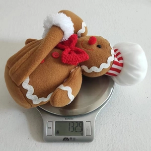Detail shot showing the weight of the gingerbread man plush toy on a kitchen scale