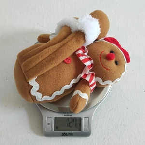 Gingerbread man plush figure showing its weight of 127g on an electronic scale